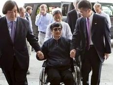 A handout photo from US Embassy Beijing Press office shows blind activist Chen Guangcheng (2nd L) sitting in a wheelchair as he is accompanied by U.S. Ambassador to China Gary Locke (2nd R) at a hospital in Beijing, May 2, 2012.