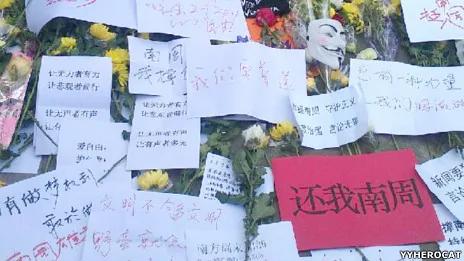 网民在广州南方日报办公楼外摆放鲜花和声援《南方周末》的标语牌（网友YYHEROCAT提供图片7/1/2013）