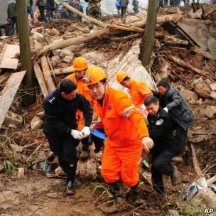 云南镇雄高坡村山体滑坡现场救援人员搬运一具遇难者遗体（11/1/2013）