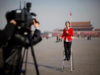 中国人大开幕期间一位记者在北京天安门广场做报道2013年3月5日