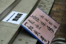 邀请乔晓阳参加公开辩论的“战书”被放在中联办台阶上(美国之音海彦拍摄)