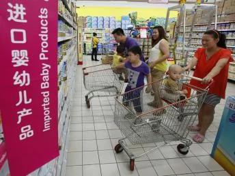 2013年7月3日，北京一家超市内的外国进口奶粉产品的货架前，细心挑选的消费者。