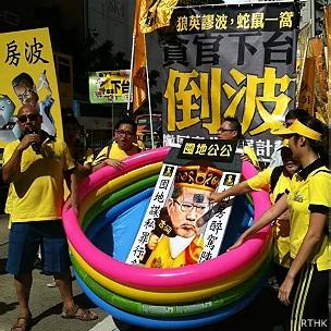 香港民主派政团人民力量示威者推着讽刺陈茂波的道具游行（香港电台图片28/7/2013）
