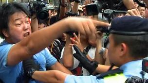 香港天水围梁振英会见群众会场外一名示威者与警员推搡（香港电台图片11/8/2013）