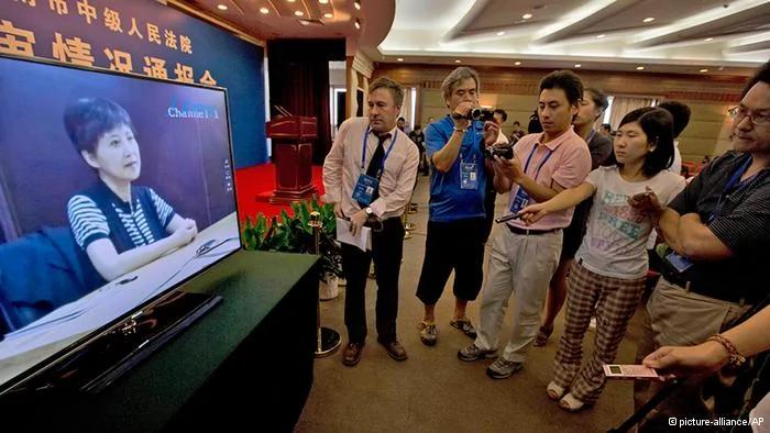 Journalists watch an online pre-recorded testimony by Gu Kailai, wife of former Chinese politician Bo Xilai before a press conference held at a hotel near the Jinan Intermediate People