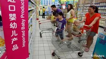 A family looks at foreign imported milk powder products at a supermarket in Beijing July3,2013. The decision by China