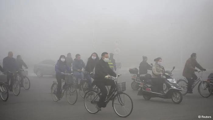 People ride along a street on a smoggy day in Daqing, Heilongjiang province, October21,2013. The highest red alert was issued for heavy smog in several cities in Heilongjiang province on Monday, according to Xinhua News Agency. The second day of heavy smog with a PM2.5 index has forced the closure of schools and highways, exceeding500 micrograms per cubic meter on Monday morning in downtown Harbin, the provincial capital. REUTERS/Stringer(CHINA- Tags: ENVIRONMENT SOCIETY) CHINA OUT. NO COMMERCIAL OR EDITORIAL SALES IN CHINA