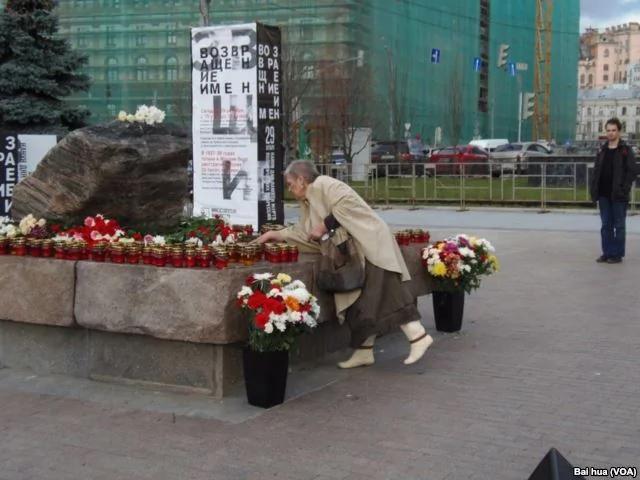 莫斯科，10月29日，一名妇女把点燃的蜡烛放在索洛维茨石头旁。(美国之音白桦拍摄)