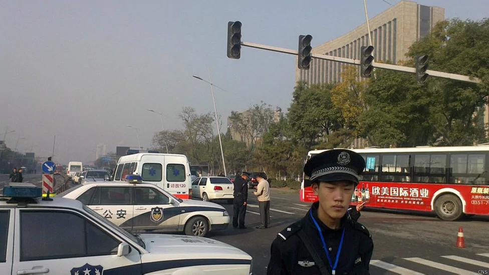 山西太原爆炸现场一名警员在封锁线外站岗（中新社图片6/11/2013）
