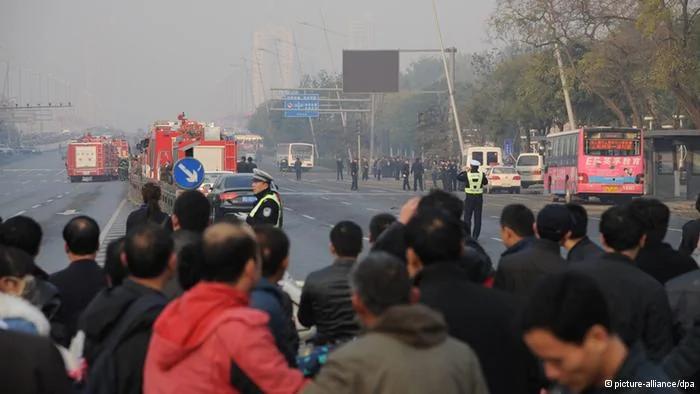 epa03937656 Onlookers watch policemen working at the site of explosions outside the provincial headquarters of China