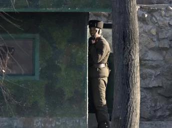 2013年12月21日，中朝边境鸭绿江对岸的朝鲜士兵正在持枪执勤