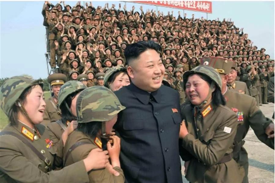 图为2014年4月金正恩在北韩官媒发布的照片中，被众女兵团团包围。当时的金正恩右额头上似乎没有看到这道伤痕。(中时资料库)