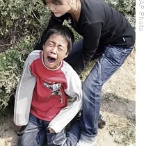 一位兒童看到母親屍體從廢墟中被扒出來後悲痛大哭