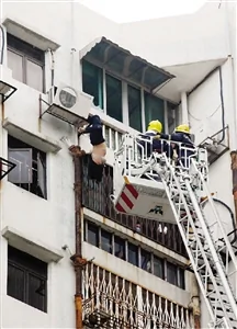 消防員升起雲梯拯救倒吊外牆的女子。