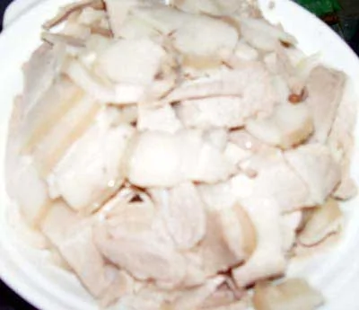 用姜、葱、花椒吊香汤，把猪肉煮至8成熟，急冻后切片，回原汤汆散，捞出。