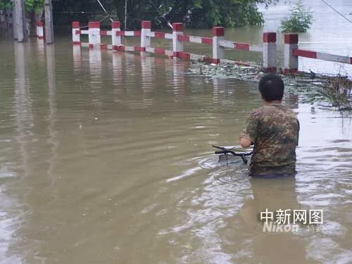  浙江瓶窑洪水中出现最牛骑车人 车身淹没水中