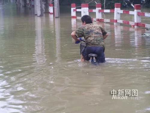  浙江瓶窑洪水中出现最牛骑车人 车身淹没水中