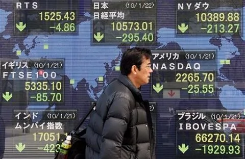 A man walks past an electronic stock board of a securities firm in Tokyo, 22 Jan 2010