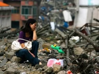 2009年5月11日，一名幼儿园院长在北川震后坍台的校址前哭泣。