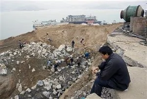 一男子在注視著工人們在加固長江河岸 (資料照片) 