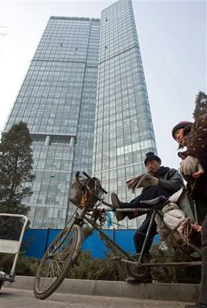 一对夫妇在北京某摩天大楼下等候捡废纸 (资料照片) 
