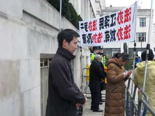 法輪功學員隨同李克強及中國商務代表團 會場外抗議