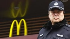 A policeman stands outside a Mcdonald's restaurant after moving away a crowd that had gathered by calls on internet social networks to join a "Jasmine Revolution" protest in central Beijing February 20, 2011. Chinese President Hu Jintao called on Saturday for stricter government...
