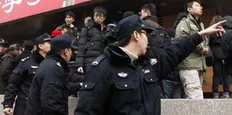 Policemen shout at a crowd that gathered outside a Mcdonald's restaurant after internet social networks called for a "Jasmine Revolution" protest in central Beijing February 20, 2011. Chinese President Hu Jintao called on Saturday for stricter government management of the Internet while...