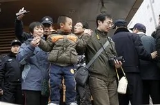 Chinese police officers urge a family to leave a McDonald's restaurant which was a planned protest site for "Jasmine Revolution" in Beijing, China, Sunday, Feb. 20, 2011. Jittery Chinese authorities staged a concerted show of force Sunday to squelch a mysterious online call for a...