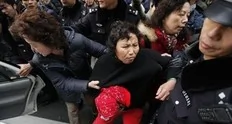 A woman is arrested by police near the Peace Cinema, where internet social networks were calling to join a "Jasmine Revolution" protest, in downtown Shanghai February 20, 2011. Police dispersed scores of people who gathered in central Beijing on Sunday after calls spread online across...