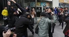 Police and unidentified men, believed to be plainclothes police, try to stop members of the media as a man is arrested after social networks called to join a "Jasmine Revolution" protest in front of the Peace Cinema in downtown Shanghai February 20, 2011. Police dispersed scores of...