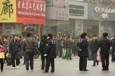 Police keep watch along the Wanfujing shopping street in Beijing after protesters gathered on February 20, 2011. Postings circulating on the Internet called on disgruntled Chinese to gather in public places in 13 major cities to mark the 'Jasmine Revolution' spreading through the Middle...