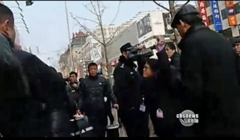 美國之音記者何宗安高舉雙手抗議被警察推擠的鏡頭(照片中右側帶眼鏡的女記者) 