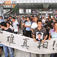 遇难者家属手拉横额在温州火车南站示威。