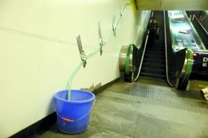 　昨日，地鐵10號線知春路站通道，牆邊擺放了水桶接水。本報記者 浦峰 攝