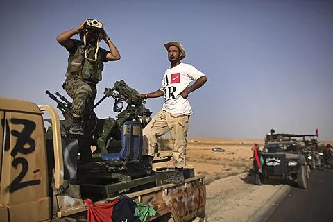 反卡扎菲的一名战士在开赴前线时用望远镜观察