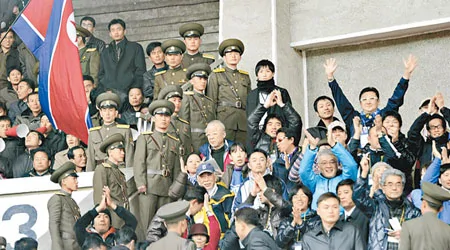 球場裡有北韓保全人員對日本球迷（右）進行監視。 （美聯社圖片）