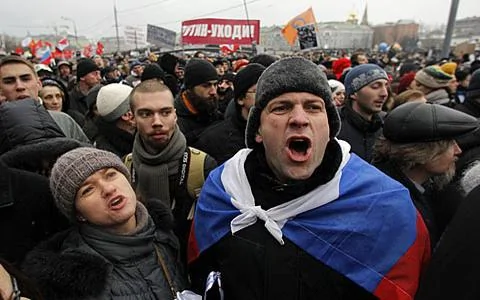  示威者12月10日在莫斯科的博洛特納亞廣場上高呼口號。遠處的橫幅上寫著「普京-辭職」
