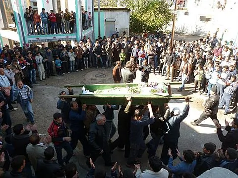 反政府抗議者12月10日在霍姆斯附近為一位被政府軍轟炸炸死的人舉行葬禮