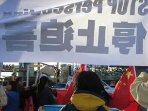 图片：法轮功组织在五星旗上方高举”停止迫害”字样。(记者萧融拍摄)