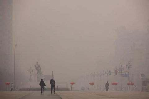 2012年1月18日兩名行人走過被霧霾籠罩的北京街頭
