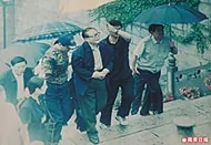 2004年6月4日，江澤民冒雨上九華山參拜地藏菩薩，由兩名保鑣挾着，神態輕鬆。