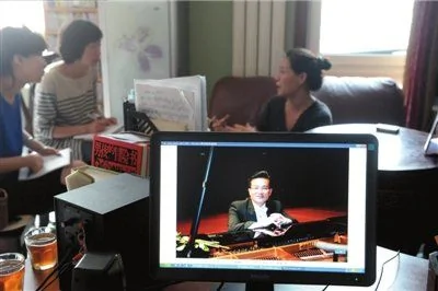 妻子楊彬在家中接受本報記者專訪，電腦屏幕上是吳龍的演出照。