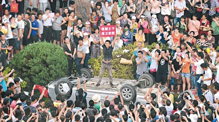 示威民众推翻车辆后高呼口号。 （法新社图片）