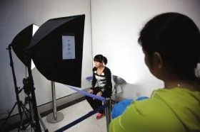 10月22日，長沙市雨花公安分局，趙常玲坐在燈架前拍攝身份證照片。對於她來說，這是一個新的開始。圖/記者辜鵬博 