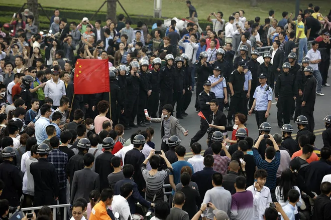 抗议活动还凸显了地方官员在中国的政治敏感时期避免社会动荡的迫切愿望。图为周日宁波的抗议者游行期间，一位抗议活动领袖向居民讲话。