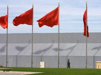 A Chinese security guard walks across flags on Tiananmen Square in Beijing, China, Monday, Oct 8, 2007. Authorities in the Chinese capital are preparing the area around the Great Hall of the People and Tiananmen Square for a major Communist Party congress next week at which President Hu Jintao is expected to fill several top posts with younger leaders loyal to his rule. (AP Photo/Ng Han Guan)