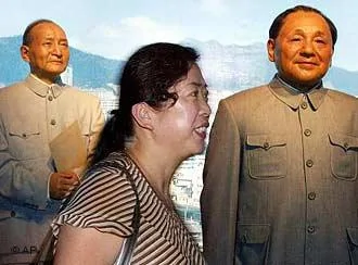 A Chinese woman walks past wax figures of former Chinese leaders Chen Yun, left, and Deng Xiaoping at a newly opened Wax Museum in Beijing, China Friday, Aug.2,2002. A first batch of35 life like statues of popular figures in China's modern history is being presented to the public as the largest of its kind in the country. Some300 to400 waxwork figures are planned for the completion of the project in2007