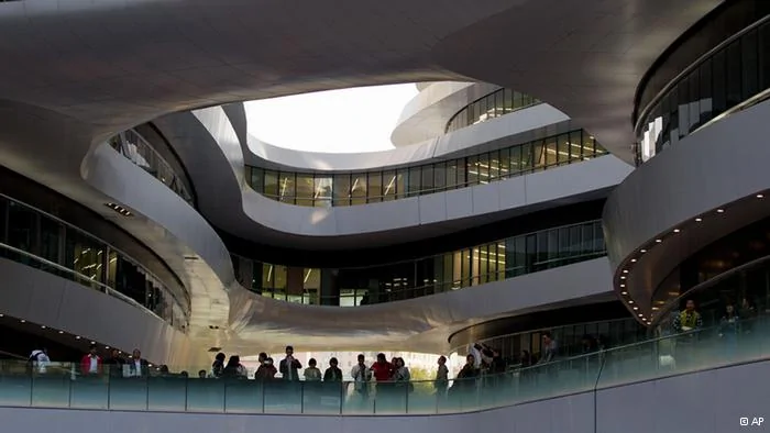 Visitors stand on a stretched and winding bridge linking between the newly opened Galaxy Soho building in Beijing Saturday, Oct.27,2012. Galaxy Soho, a new office, retail and entertainment building, designed by Iraqi-British architect Zaha Hadid, winner of the Pritzker Architecture Prize in2004, and the Stirling Prize in2010 and2011.(Foto:Andy Wong/AP/dapd)
