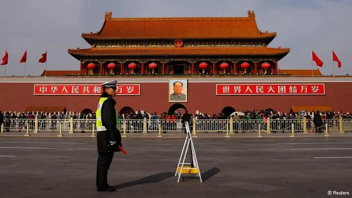 A policeman blocks the street in front of the giant portrait of former Chinese chairman Mao Zedong at Beijing's Tiananmen Gate November7,2012. Just days before the party's all-important congress opens, China's stability-obsessed rulers are taking no chances and have combed through a list all possible threats, avian or otherwise. Their list includes bus windows being screwed shut and handles for rear windows in taxis-- to stop subversive leaflets being scattered on the streets-- plus balloons and remote control model planes. The goal is to ensure an image of harmony as President Hu Jintao prepares to transfer power as party leader to anointed successor Vice President Xi Jinping at the congress, which starts on Thursday. REUTERS/Petar Kujundzic(CHINA- Tags: POLITICS)